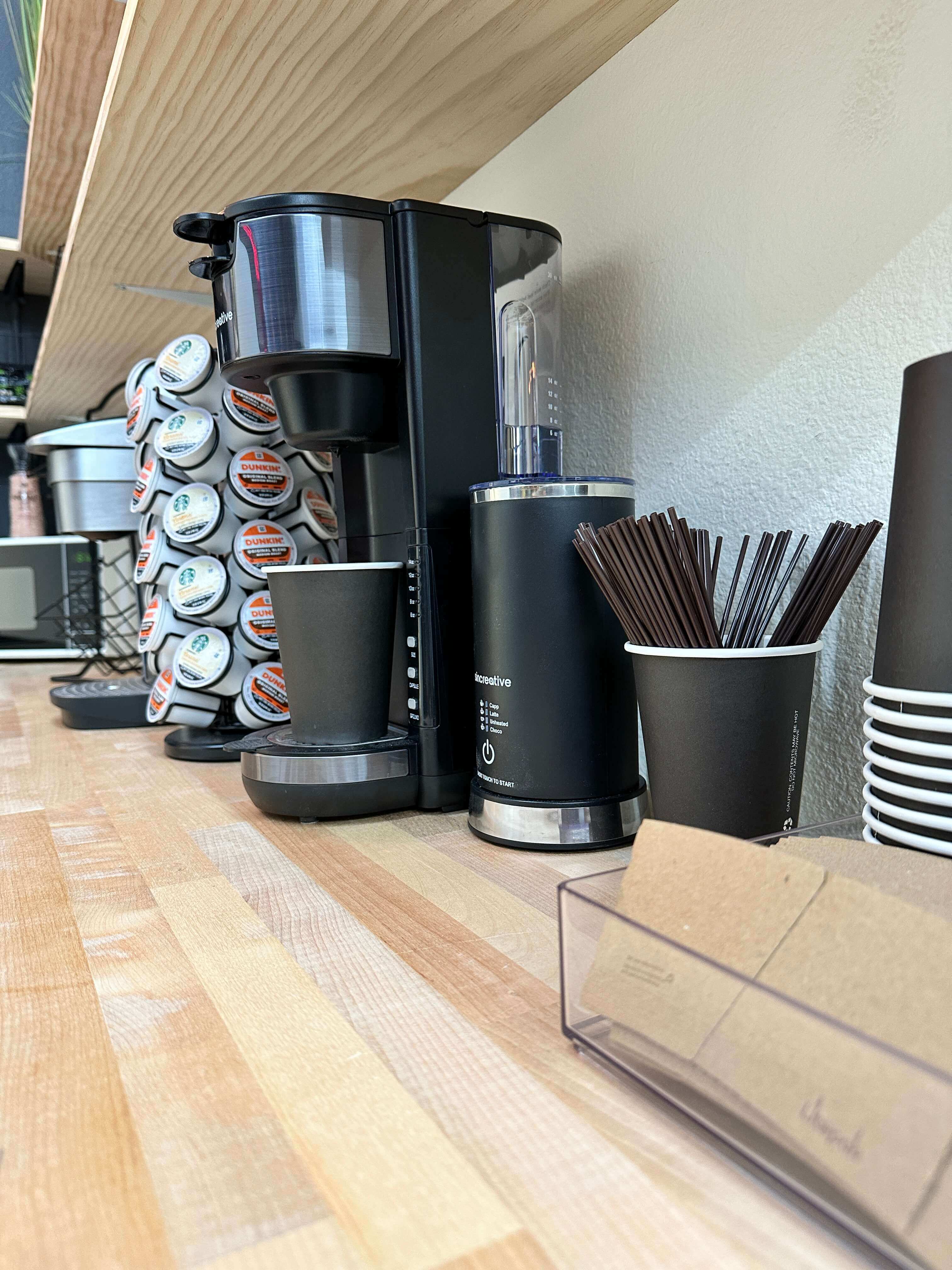 a photo of the kitchen: fridge, coffee maker, snacks
