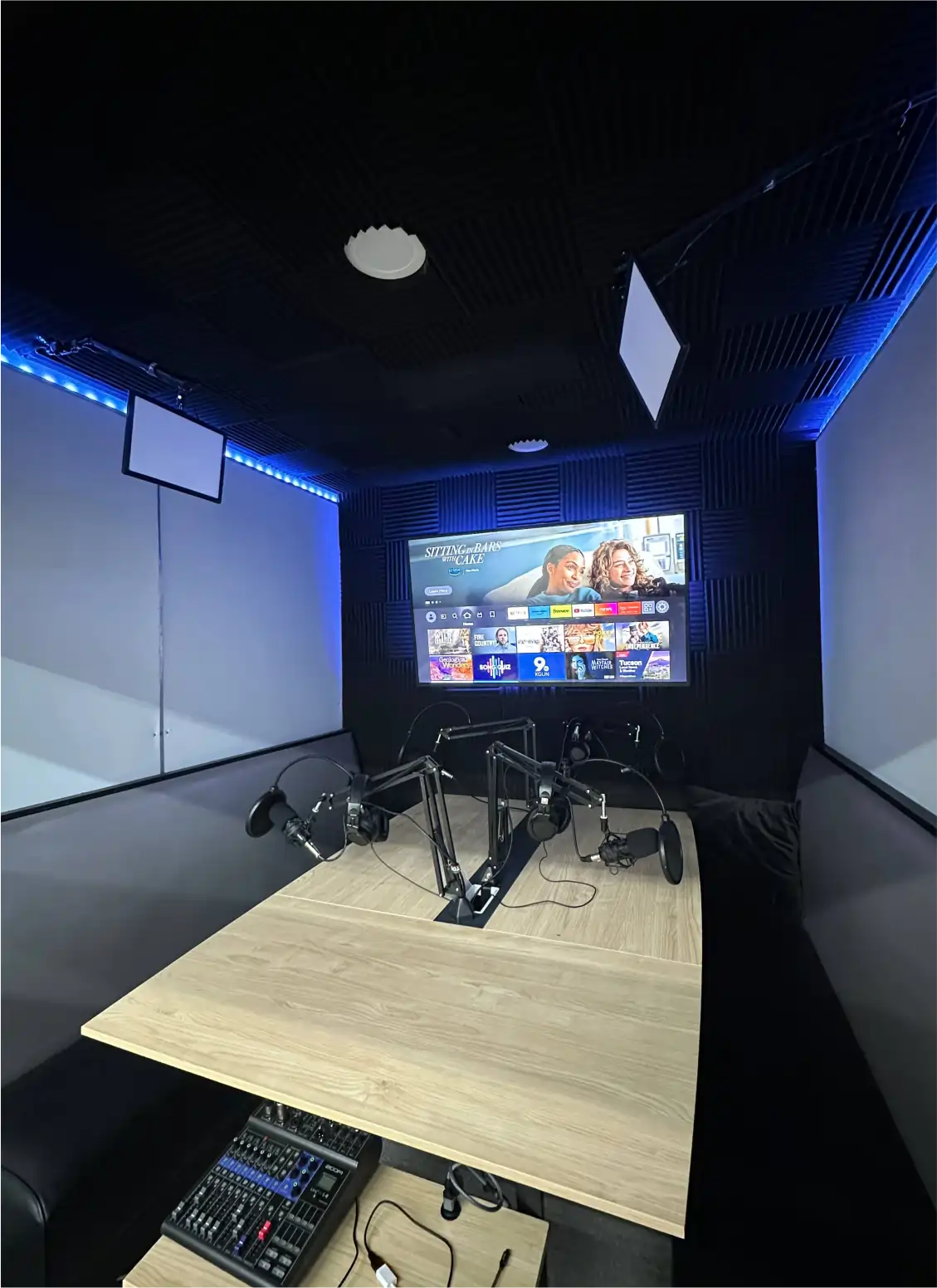 inside the podcast studio: table, mics, tv