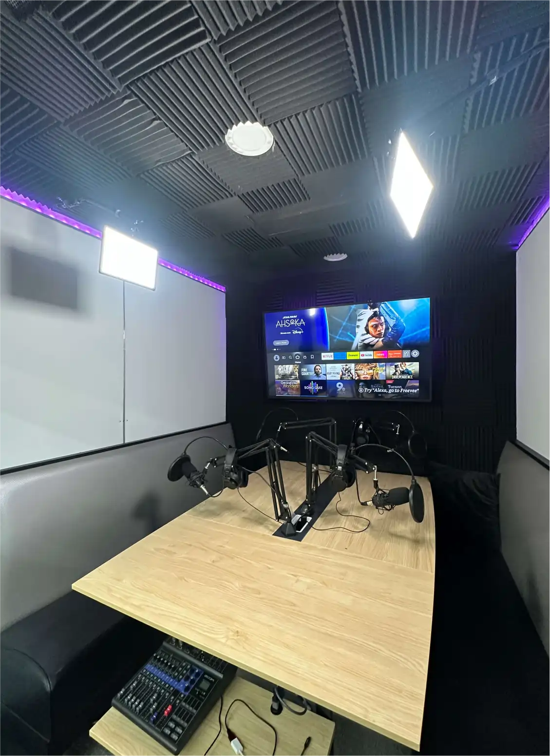 inside the podcast studio: table, mics, tv
