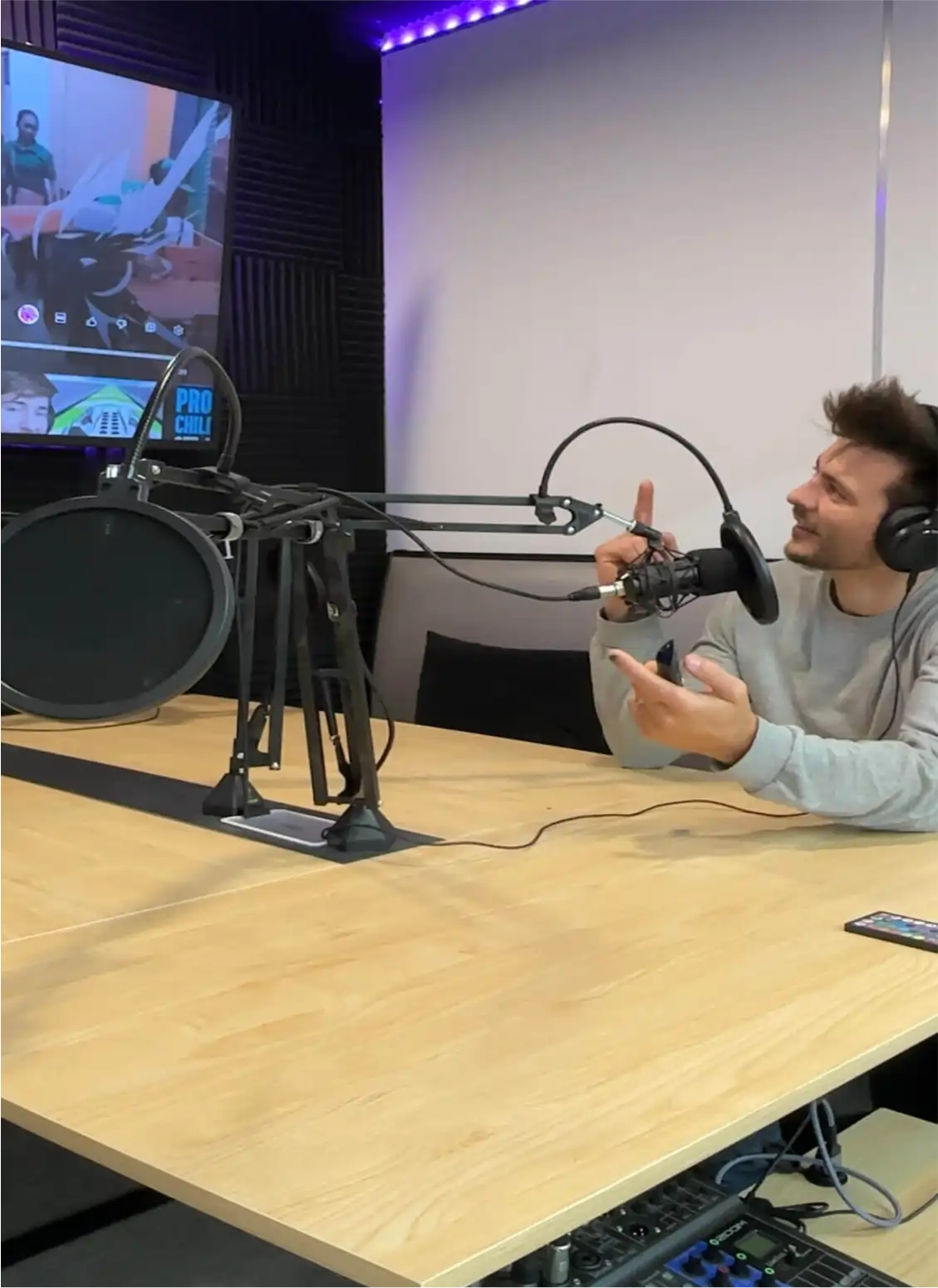 inside the podcast studio: table, mics, tv