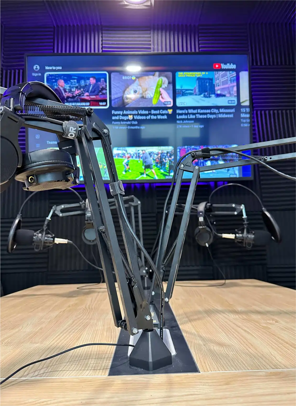inside the podcast studio: table, mics, tv
